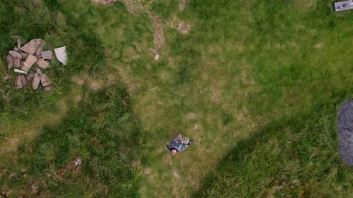 Aerial of a Man Walks Along the Pathway Through Green Meadow