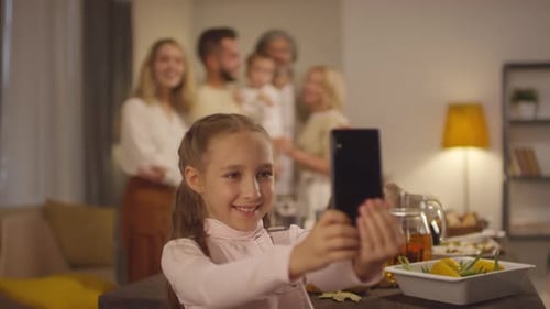 Happy Girl Takes Photo of Family Gathering