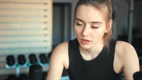 Pretty Woman in the Gym Exercising Her Legs Doing Cardio Training on Bicycle