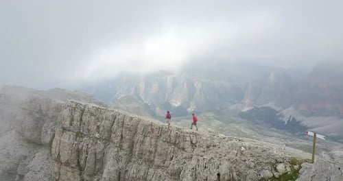 Aerial drone view of a man and woman couple hiking in the mountains