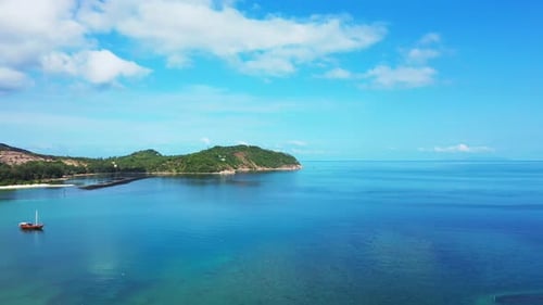 Peaceful blue turquoise lagoon with fishing boats floating on calm water reflecting bright sky with