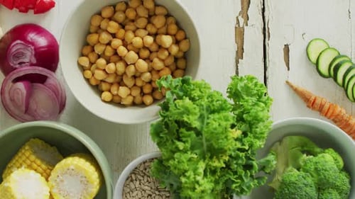 Video of bowls of fresh vegetables over white rustic background