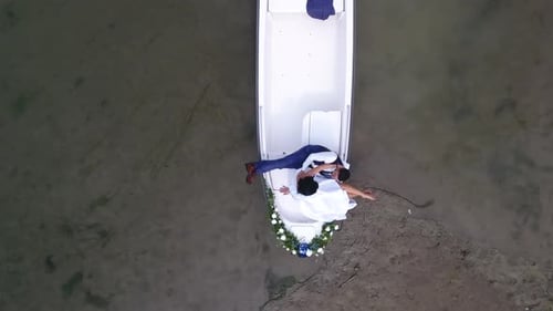 Newlyweds in Boat on Shore from Above