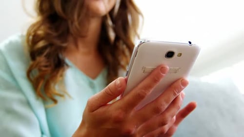 Woman Using Mobile Phone at Home