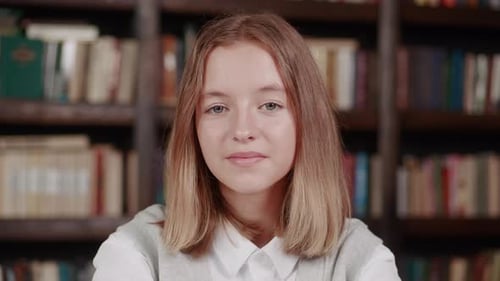 Close Up Portrait of Young Pretty School Girl Years 1214 Smiling Happy Looking at Camera in Library