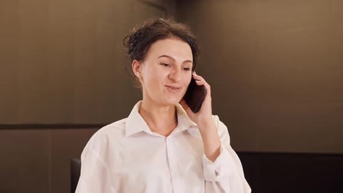 Smiling Woman Talking on Mobile Phone Indoors