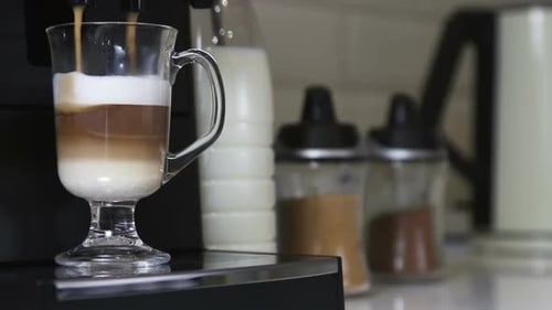 Latte Being Poured from Machine Into Glass