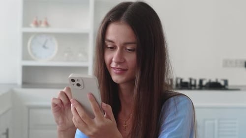 Smiling Woman Using Smartphone Indoors