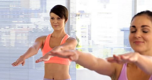 Two Women Stretch in a Bright Studio