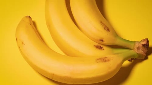 Frische Bananen auf gelbem minimalistischem Hintergrund