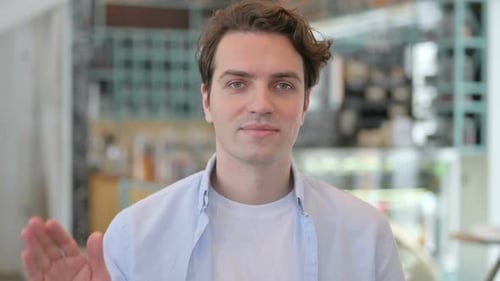 Young Adult Waving Hand in Friendly Greeting