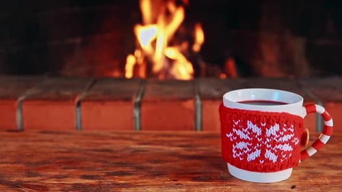 Mug by Fireplace with Christmas Knit Sleeve