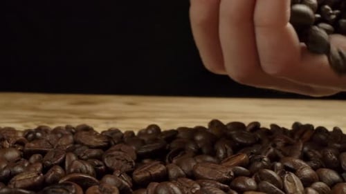 Roasted Coffee Beans Being Poured on Wooden Surface