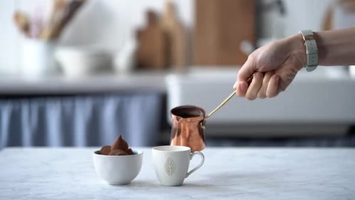 Coffee Being Poured Near Truffles in Bright Home