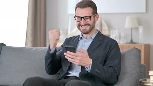 Happy Man Celebrating Good News on Smartphone