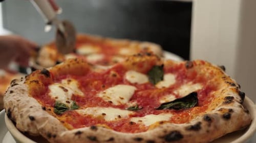 Chef in the Pizzeria Prepares a Pizza and Decorates It with Parmesan Cheese Pepper and Basil