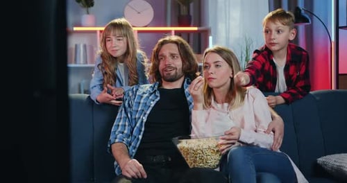 Family Watches TV Together and Eats Popcorn