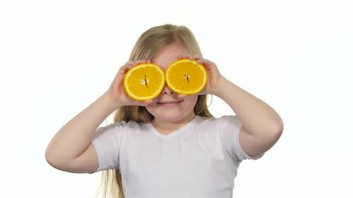 Playful Child with Orange Slices Posing on White