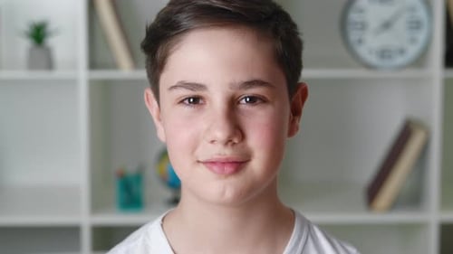 Teen Boy Smiling Portrait in Front of Bookshelf
