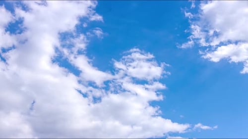 Fluffy White Clouds Drifting Across Blue Sky Time Lapse