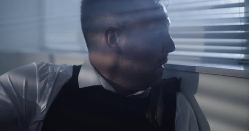 Sweaty Man Speaks into Walkie Talkie, Peering out Window