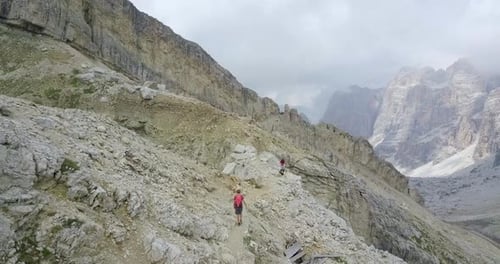 Aerial drone view of a man and woman couple hiking in the mountains