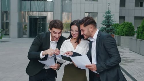 Business Team Celebrates Success Outside Office Building