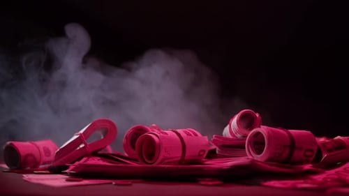 Rolls of Money Lit with Red and Pink