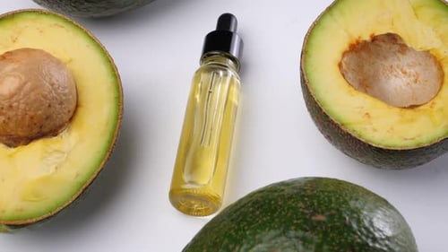 Avocado oil with avocado fruit on white background. Avocado is a highly nutritious fruit.