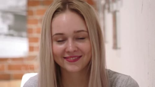 Smiling Woman Waving and Talking Indoors