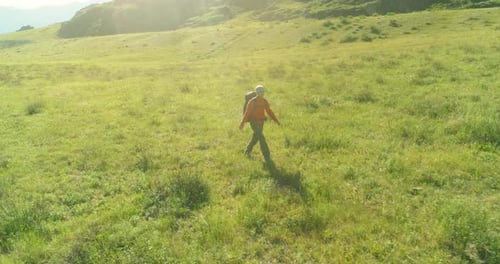 Flight Over Backpack Hiking Tourist Walking Across Green Mountain Field