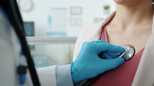 Doctor Listens to Patient's Heart with Stethoscope