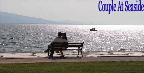 Couple Relaxing on Bench by the Ocean