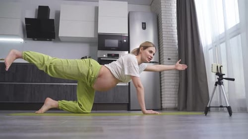 Pregnant Woman Exercising on Yoga Mat in Kitchen