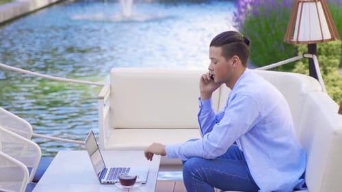 Man Working on Laptop by Water Fountain