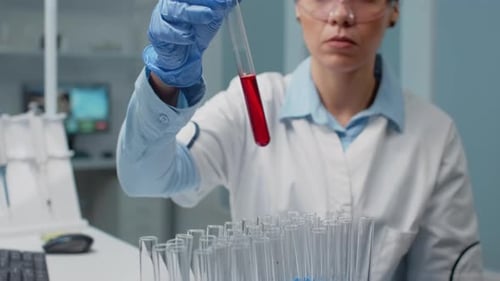 Female Scientist Analyzes Blood Sample in Lab