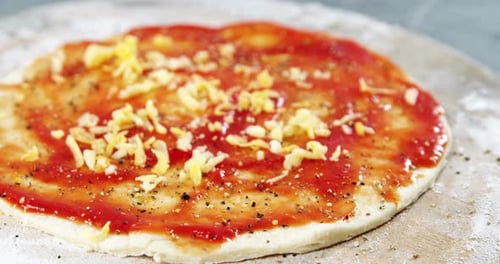 Untar los ingredientes de queso sobre la base de pizza