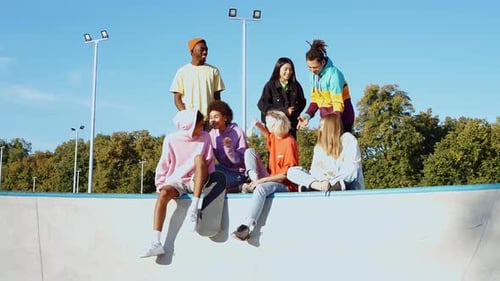 Friends Chatting at the Skatepark on a Sunny Day