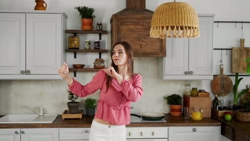 Woman Dances in Kitchen with Pink Blouse
