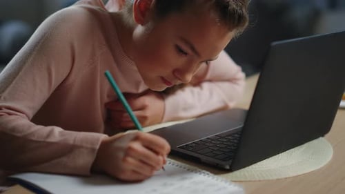 Girl Studying At Home Using Laptop and Notebook