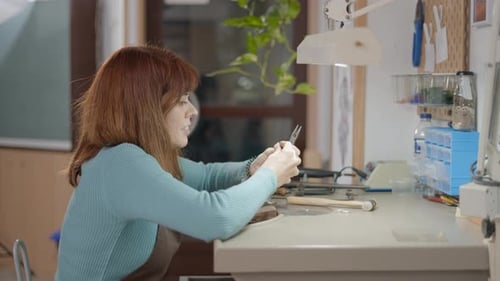 Woman Crafting Jewelry at Her Artisan Workspace