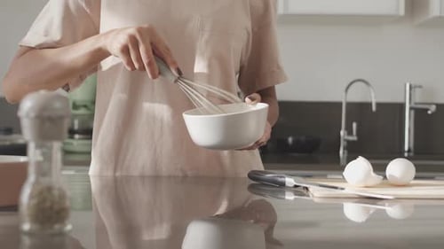Woman in Kitchen Whisking Ingredients in Bowl