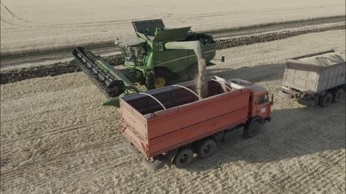 Harvester Offloads Grain to Truck in Rural Field
