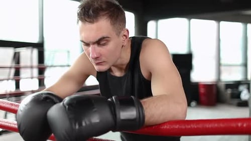 Boxer Resting in Boxing Ring in Gym