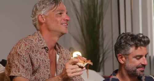 Glücklicher Mann, der zu Hause Pizza isst