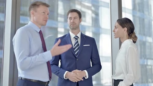 Middle Aged Businessman Having Conversation with His Assistants in Office