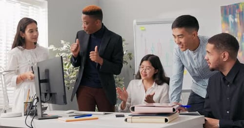 Handsome Company Head Discusses Work Strategies with Coworkers Leans Over the Desk Explains