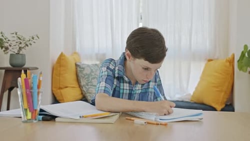 Junge sitzt zu Hause und bereitet Hausaufgaben für die Schule vor