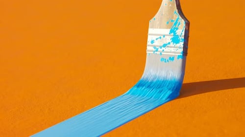 Paintbrush Creating Fluid Blue Line on Orange Background