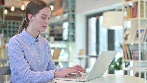 Laptop Use By Attractive Young Businesswoman in Cafe